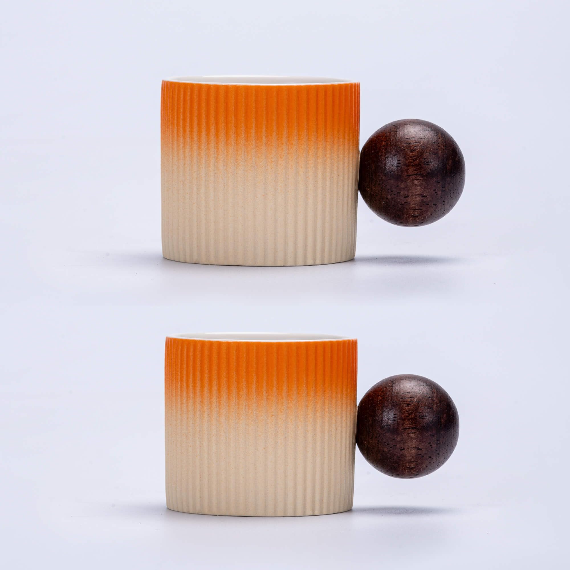 Two ribbed ceramic containers with gradient color and wooden spheres on a light gray background