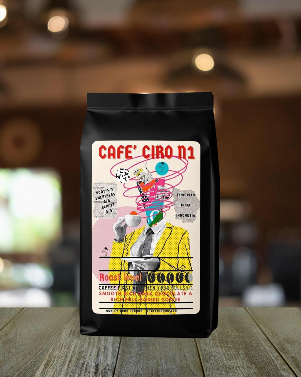 Black coffee bag with colorful design and text on a wooden surface