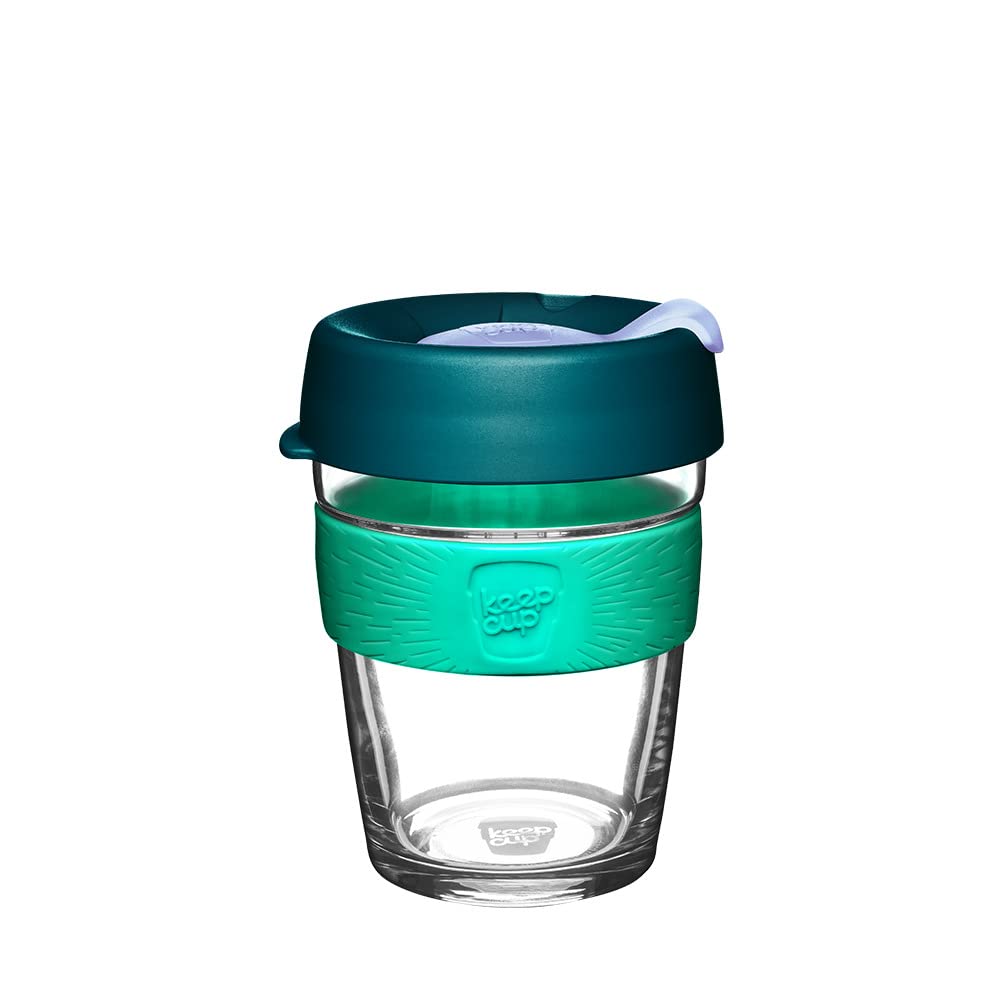A reusable glass travel tumbler with a dark teal lid, a bright teal silicone grip, and a clear glass body, shown on a plain white background.